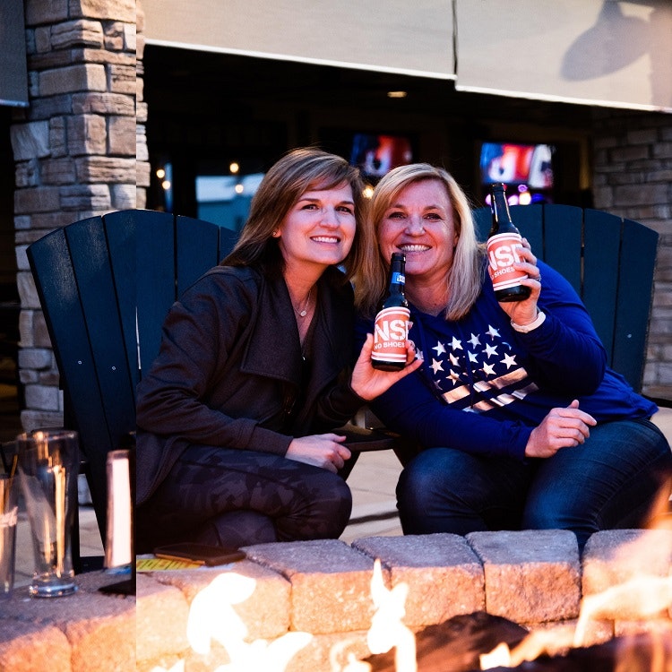 Two women sitting at a fire pit