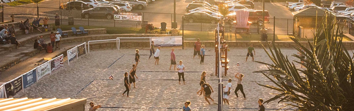 people playing volleyball on sand courts
